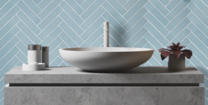 sink on stone countertop with aqua blue herringbone tile wall