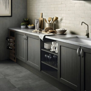 Light kitchen counter with dark cabinets, dark tile floor, and cream brick backsplash