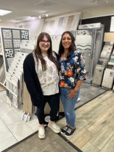 Two women standing in front of tile displays