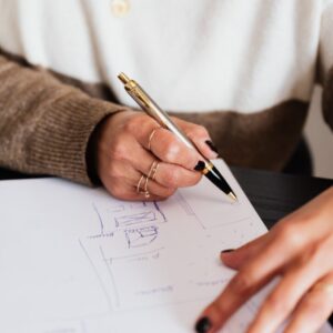 close-up image of a person drawing or writing plans on a piece of paper